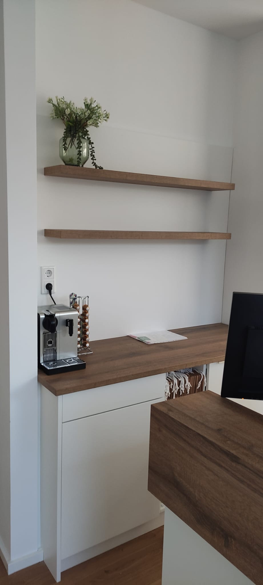 Kaffeeecke mit Wandregalen hinter dem Empfang
