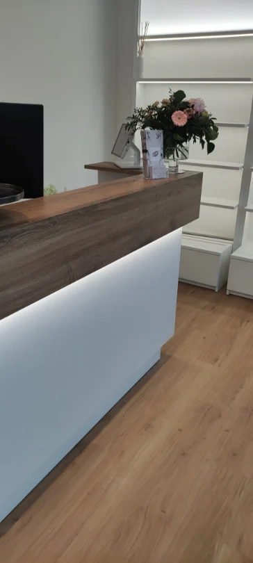 Beleuchtete Empfangstheke mit Blumenstrauß bei Beauty Time