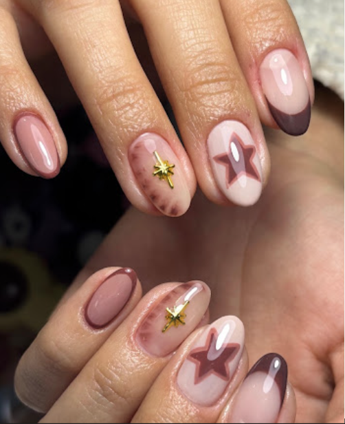 Nageldesign in Rosé mit Sternen und goldenen Akzenten